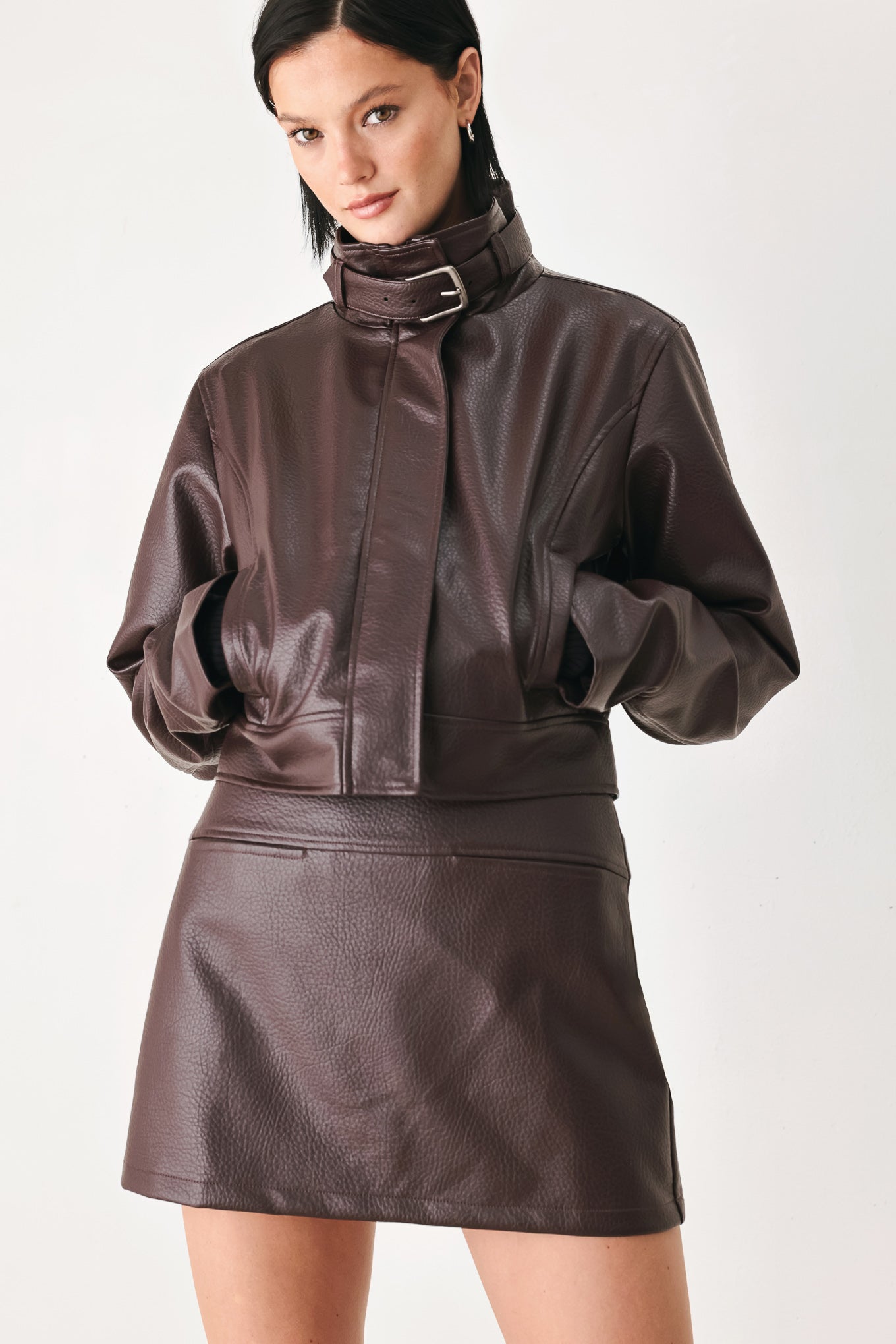 A model wearing a dark brown faux-leather jacket | FREEMARKET
