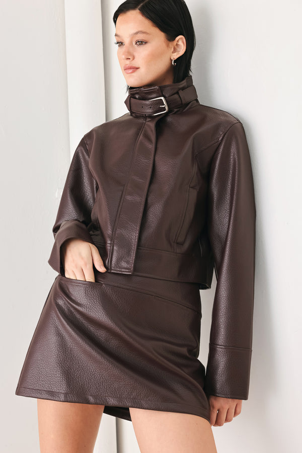 A model wearing a dark brown faux-leather jacket | FREEMARKET
