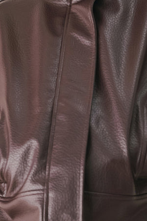 A model wearing a dark brown faux-leather jacket | FREEMARKET
