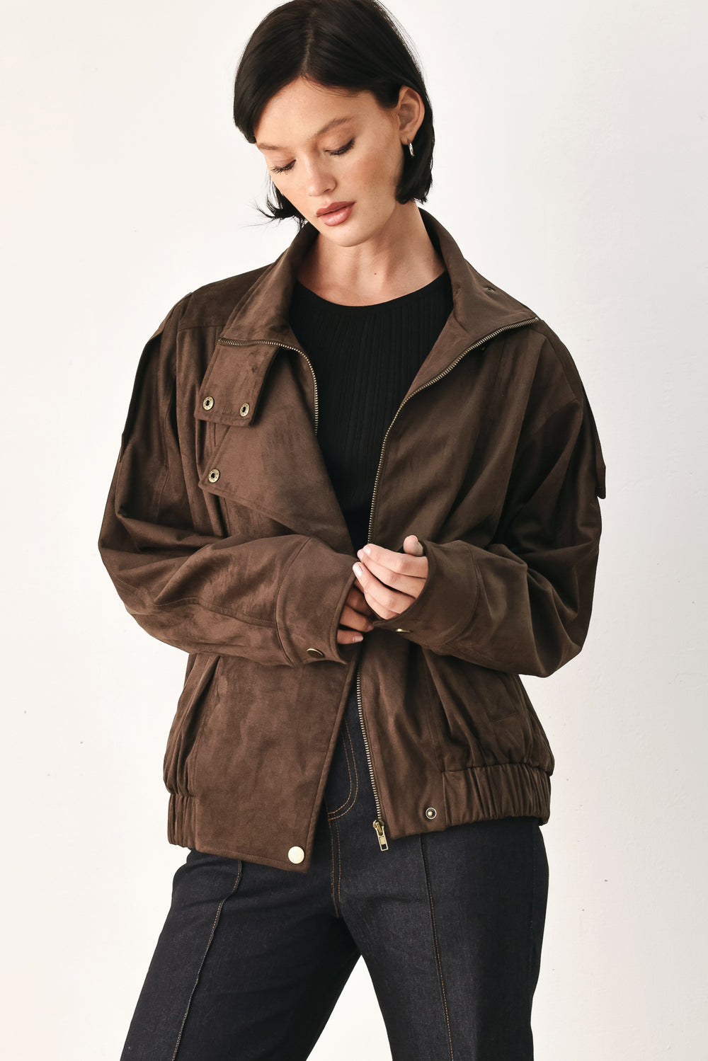 A woman wearing a dark brown suede jacket with a high collar and gold-tone snap buttons | FREEMARKET