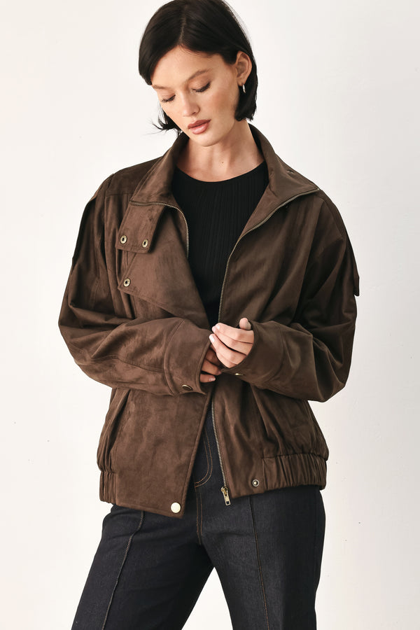 A woman wearing a dark brown suede jacket with a high collar and gold-tone snap buttons | FREEMARKET