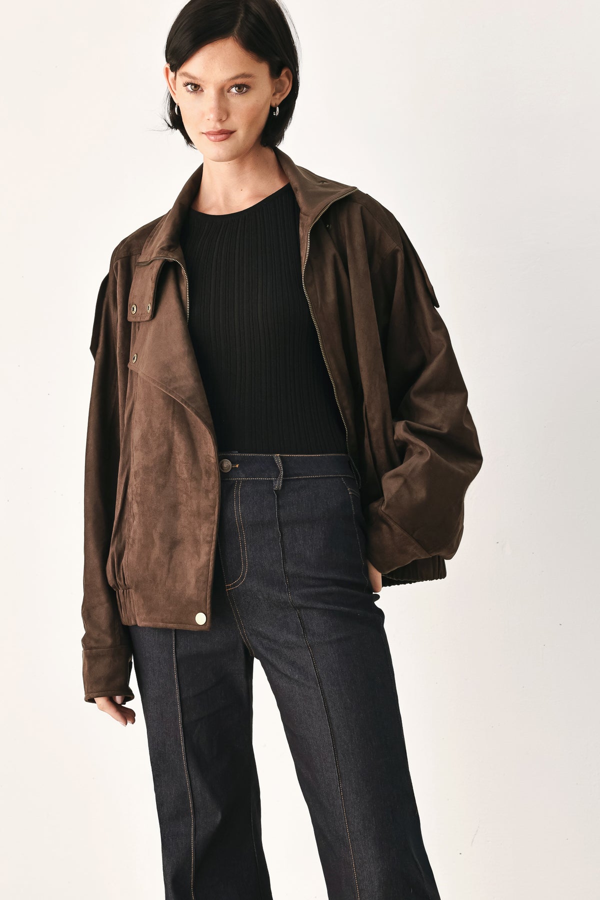 A woman wearing a dark brown suede jacket with a high collar and gold-tone snap buttons | FREEMARKET