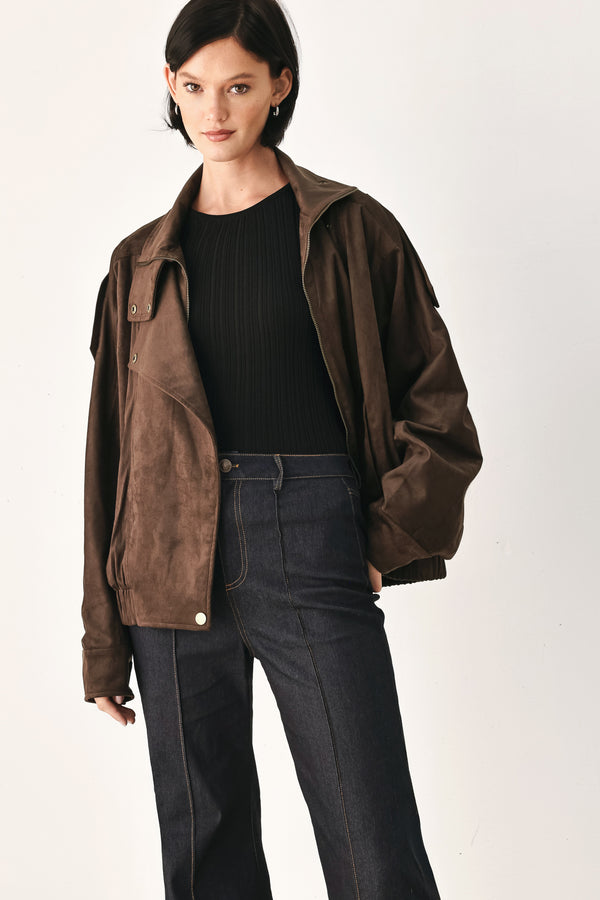 A woman wearing a dark brown suede jacket with a high collar and gold-tone snap buttons | FREEMARKET
