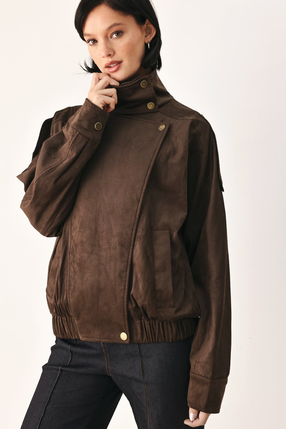 A woman wearing a dark brown suede jacket with a high collar and gold-tone snap buttons | FREEMARKET