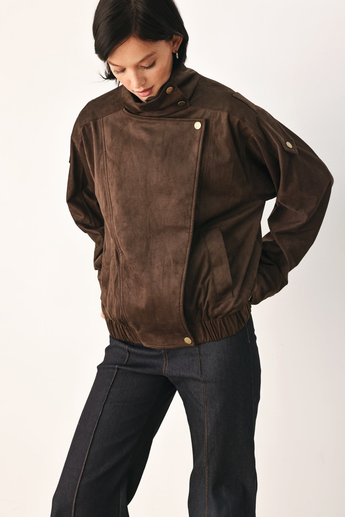 A woman wearing a dark brown suede jacket with a high collar and gold-tone snap buttons | FREEMARKET