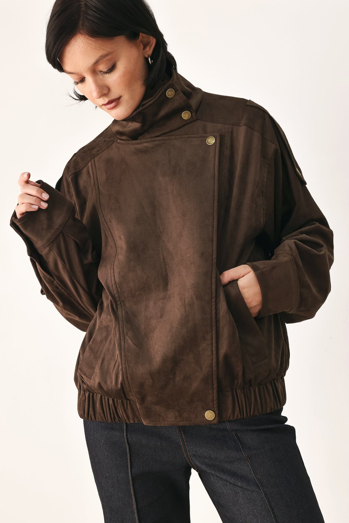 A woman wearing a dark brown suede jacket with a high collar and gold-tone snap buttons | FREEMARKET