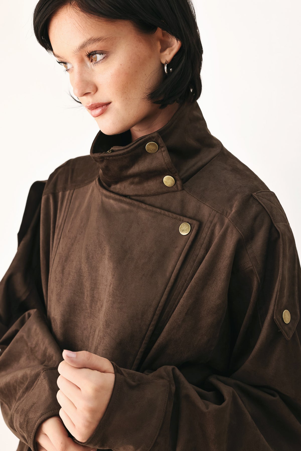 A woman wearing a dark brown suede jacket with a high collar and gold-tone snap buttons | FREEMARKET
