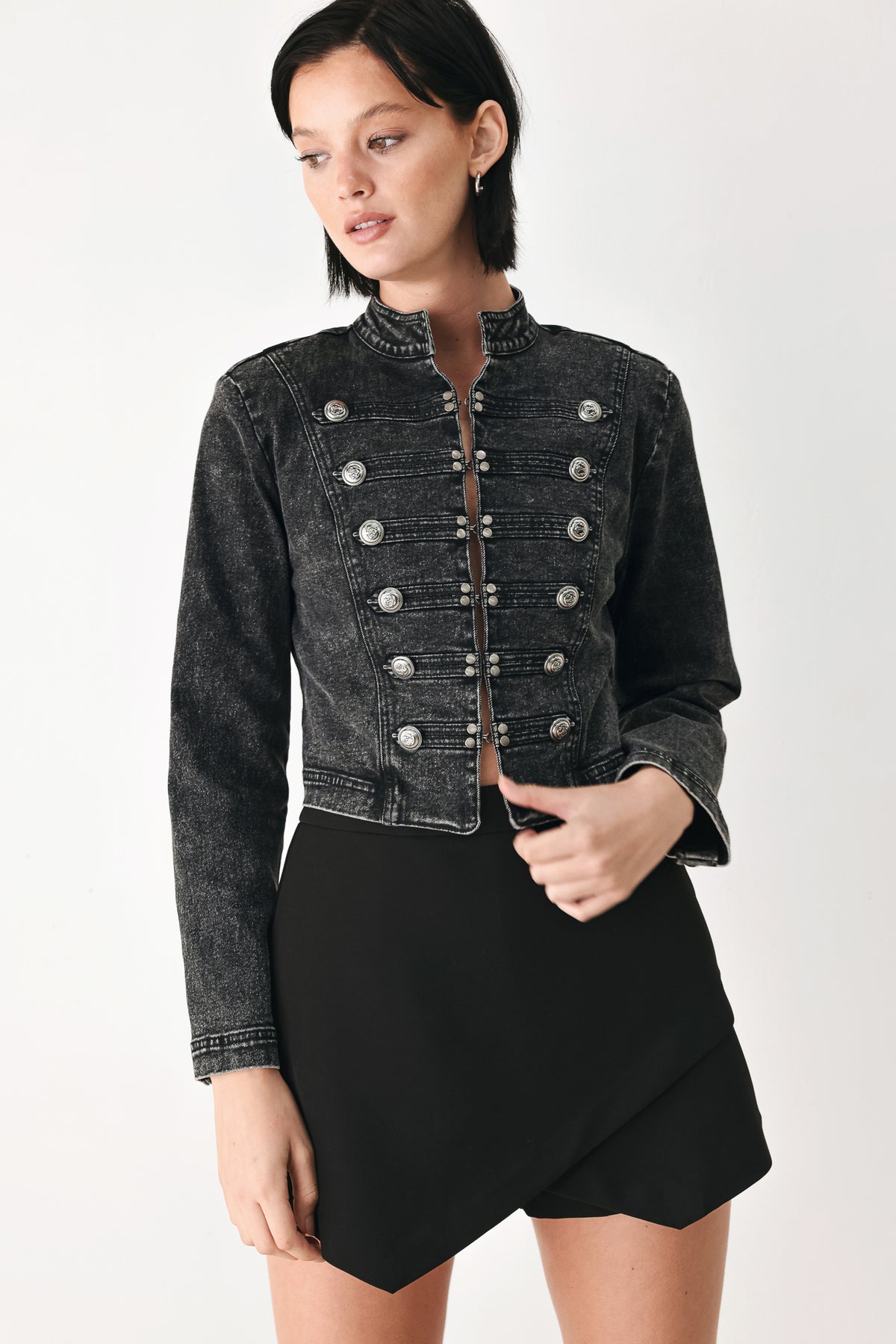 A model wearing a cropped black washed denim jacket with silver-tone decorative buttons | FREEMARKET