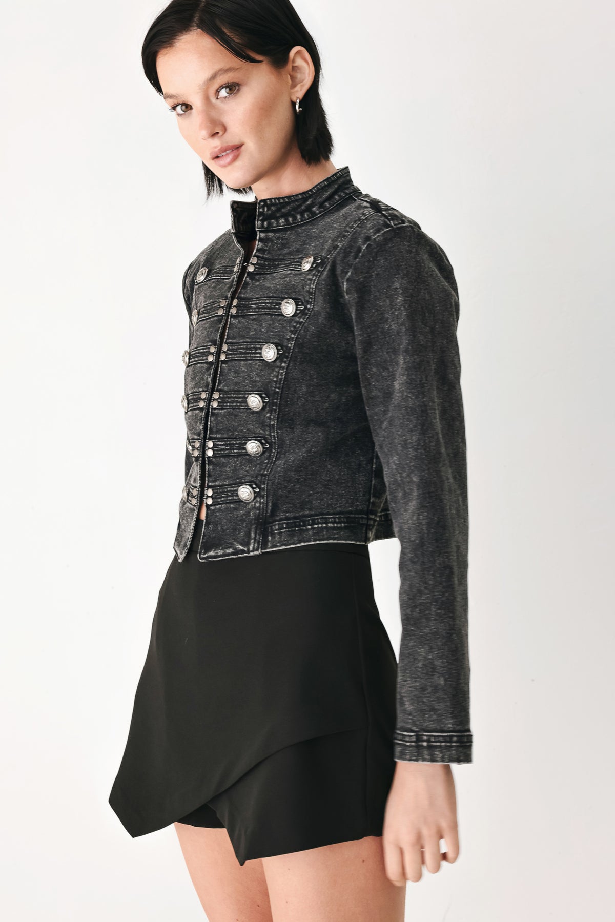A model wearing a cropped black washed denim jacket with silver-tone decorative buttons | FREEMARKET