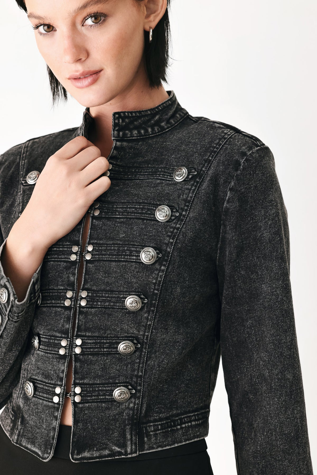 A model wearing a cropped black washed denim jacket with silver-tone decorative buttons | FREEMARKET