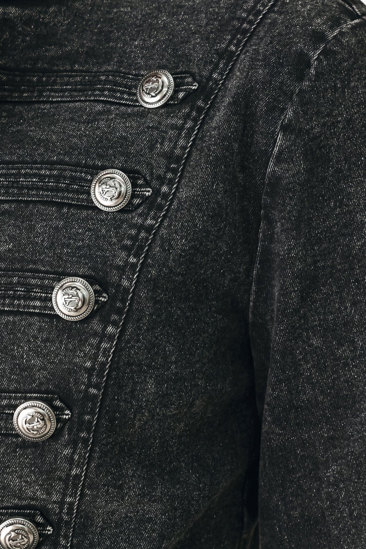 A model wearing a cropped black washed denim jacket with silver-tone decorative buttons | FREEMARKET