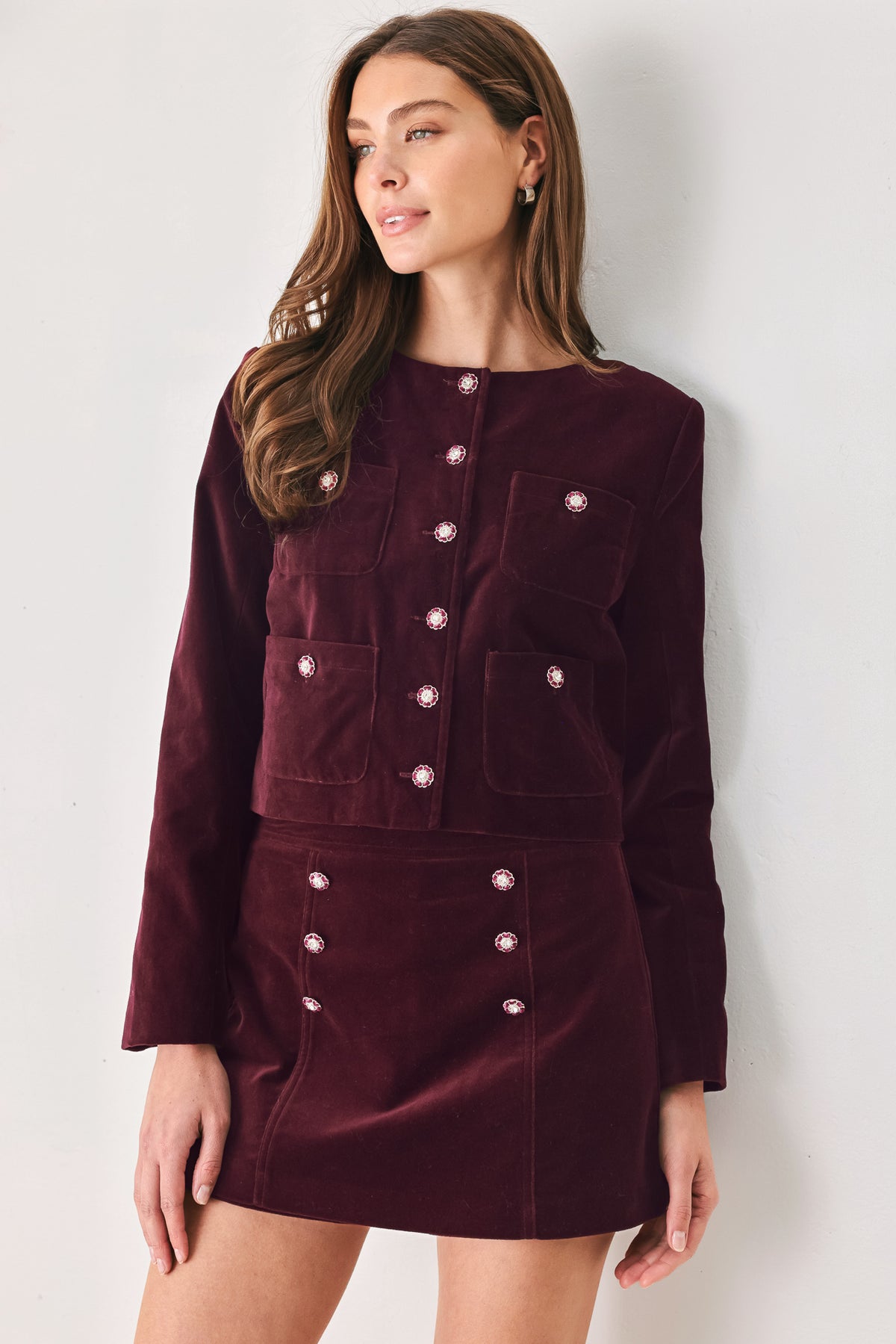 Woman wearing a burgundy long sleeve cropped jacket with buttons along the front center and on four front pockets | FREEMARKET