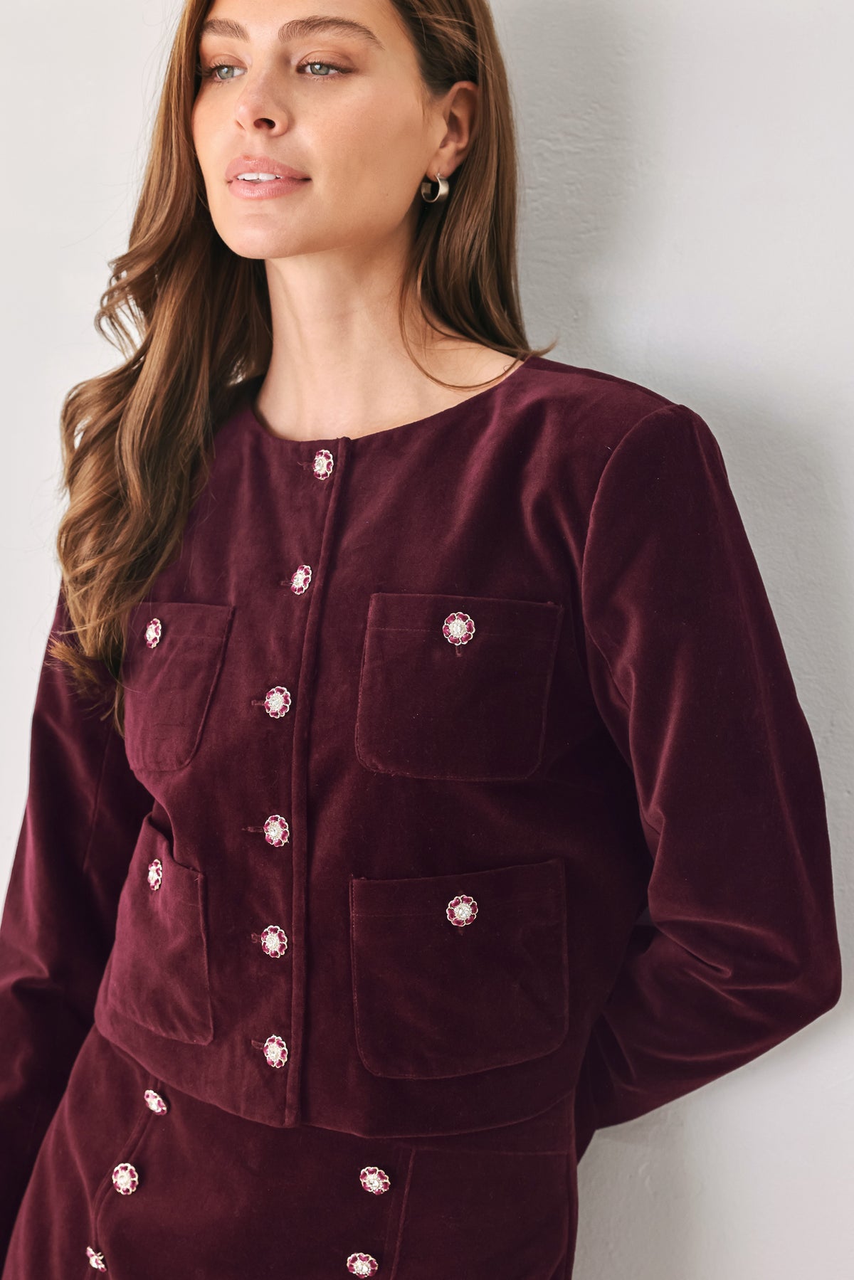Woman wearing a burgundy long sleeve cropped jacket with buttons along the front center and on four front pockets | FREEMARKET
