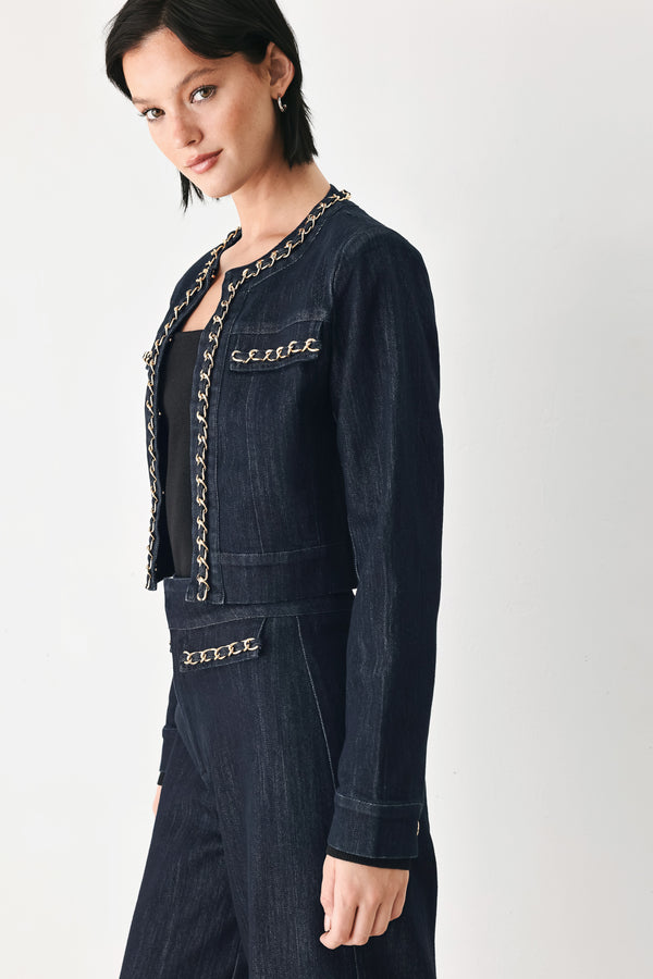 A model wearing a dark indigo denim jacket featuring gold chain trim details on the collar, chest pockets | FREEMARKET