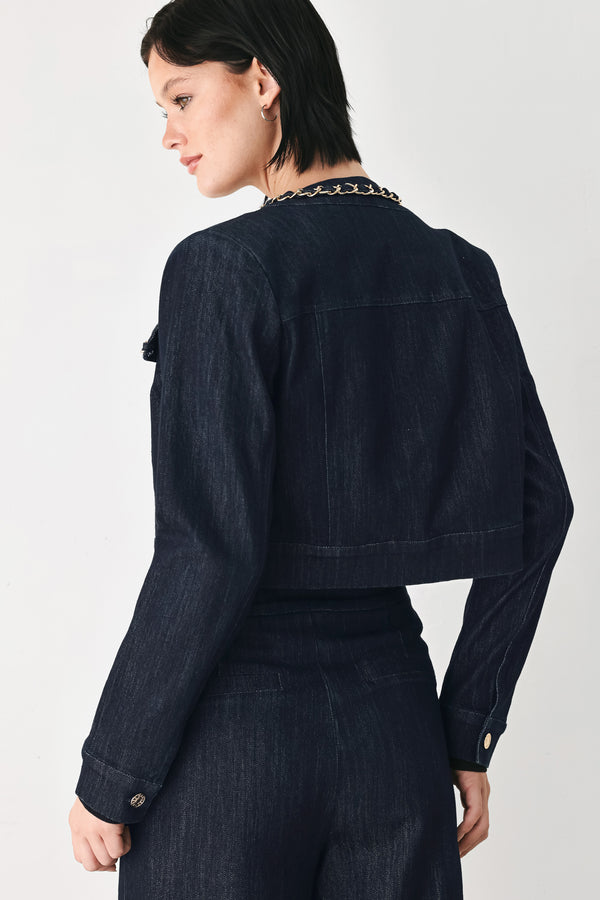 A model wearing a dark indigo denim jacket featuring gold chain trim details on the collar, chest pockets | FREEMARKET