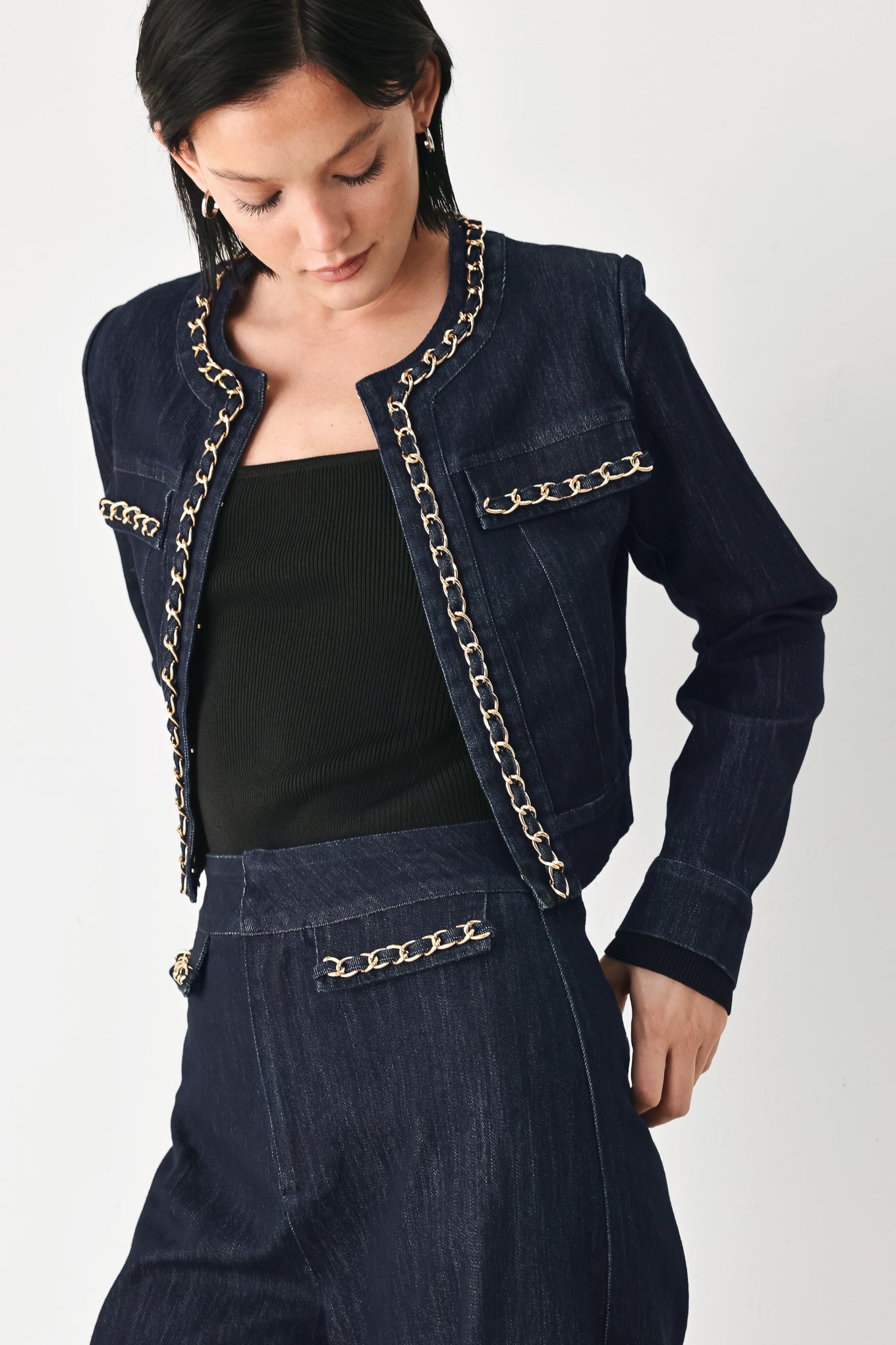 A model wearing a dark indigo denim jacket featuring gold chain trim details on the collar, chest pockets | FREEMARKET