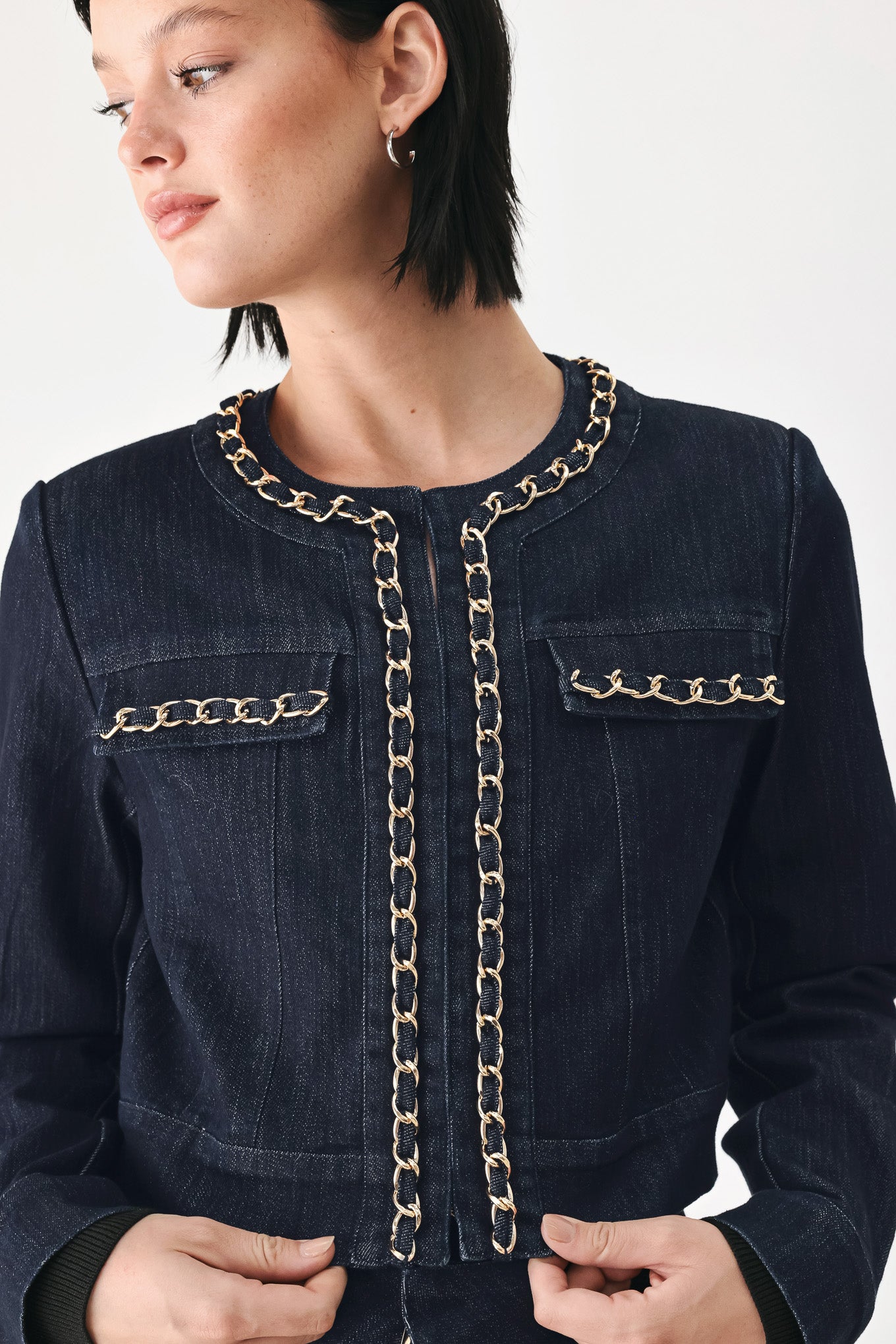 A model wearing a dark indigo denim jacket featuring gold chain trim details on the collar, chest pockets | FREEMARKET