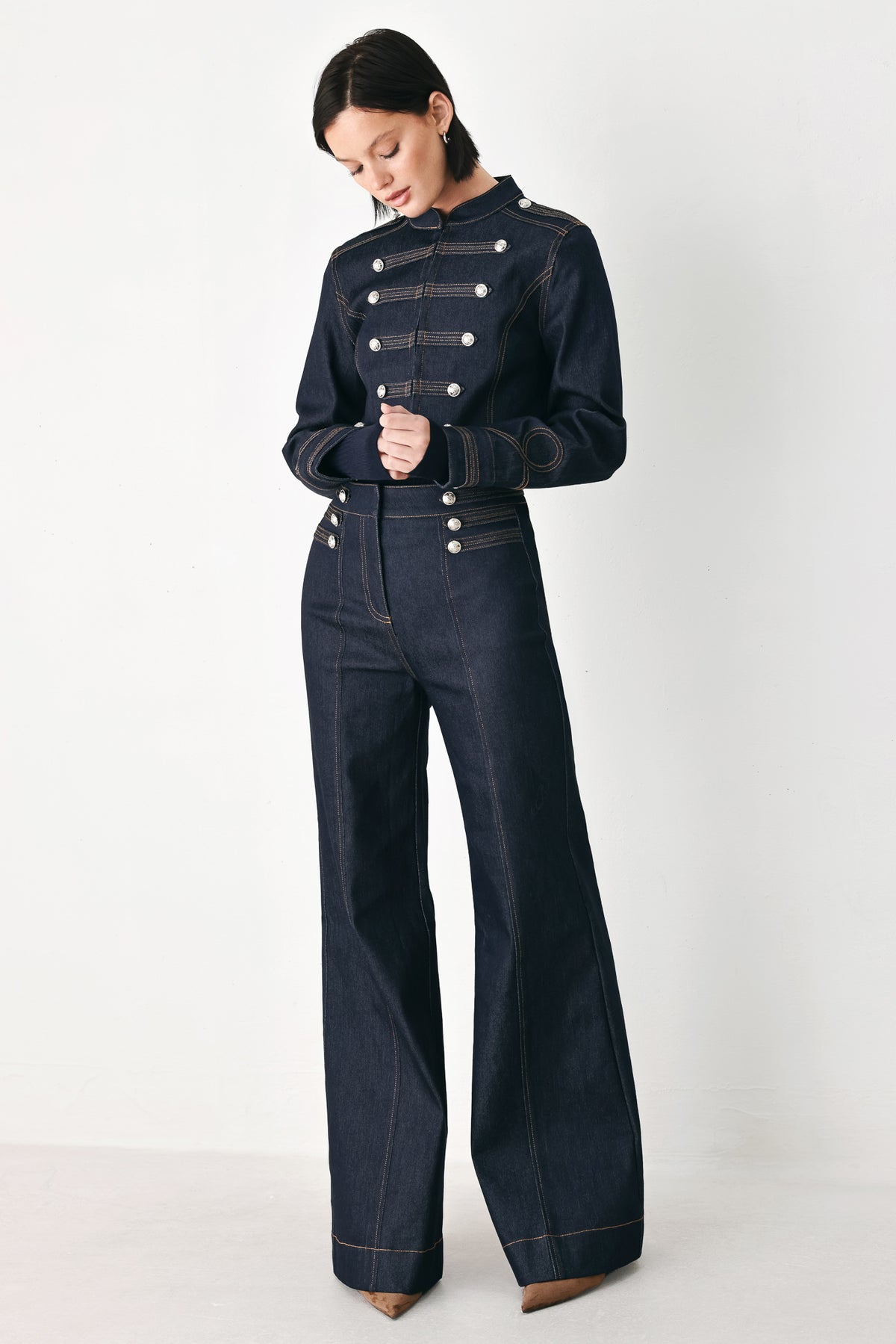 A model wearing a dark indigo denim military-style jacket with double-breasted silver buttons | FREEMARKET