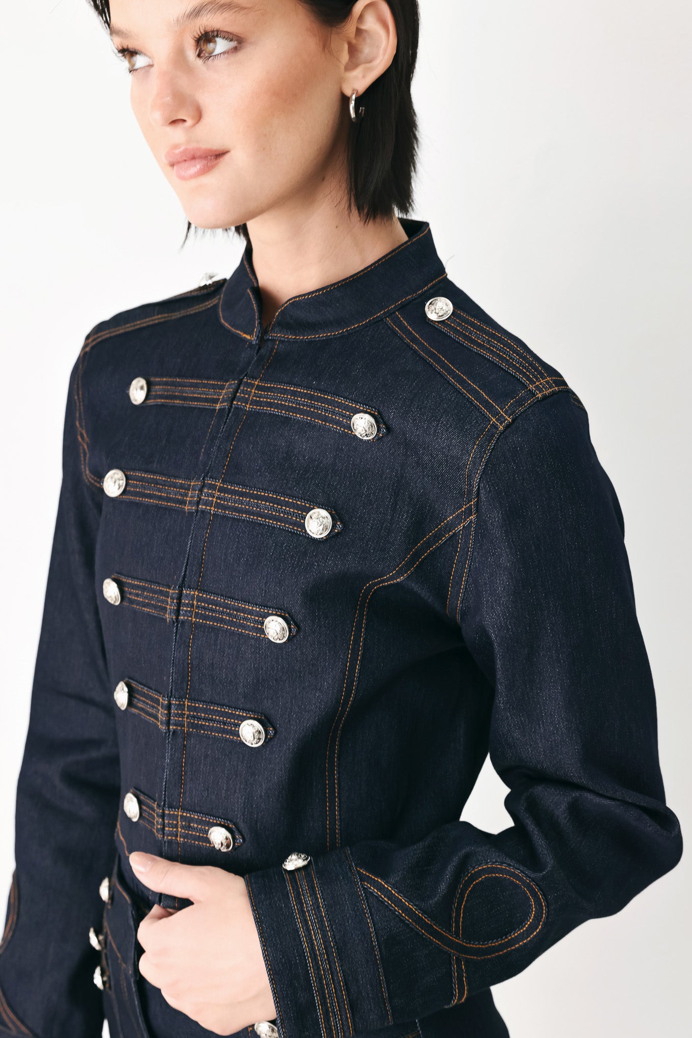 A model wearing a dark indigo denim military-style jacket with double-breasted silver buttons | FREEMARKET