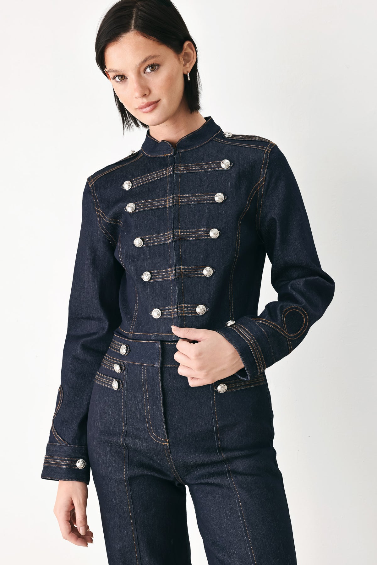 A model wearing a dark indigo denim military-style jacket with double-breasted silver buttons | FREEMARKET
