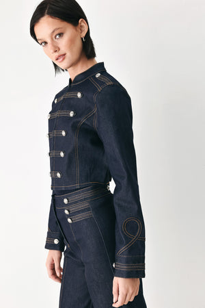 A model wearing a dark indigo denim military-style jacket with double-breasted silver buttons | FREEMARKET