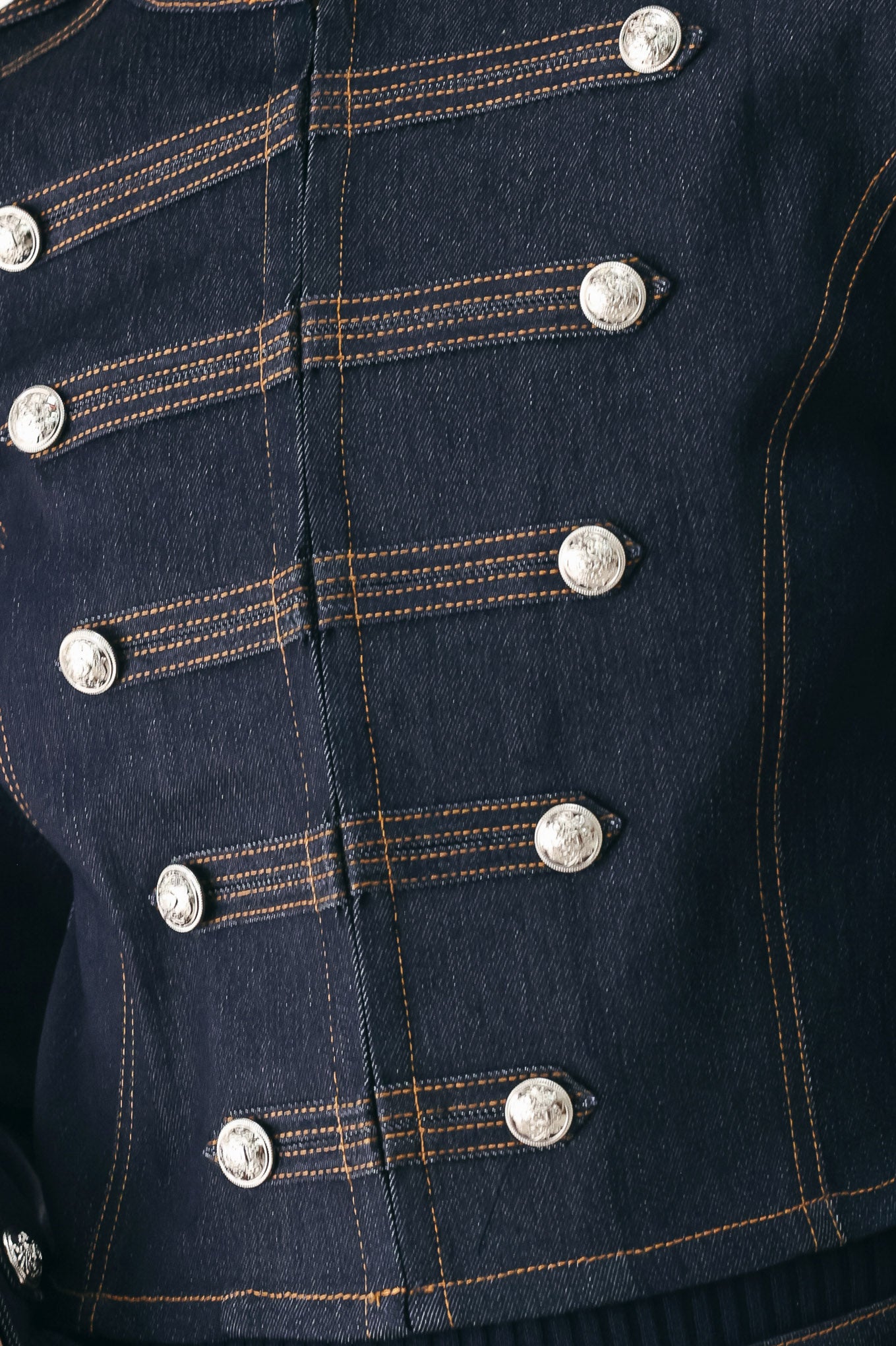 A model wearing a dark indigo denim military-style jacket with double-breasted silver buttons | FREEMARKET