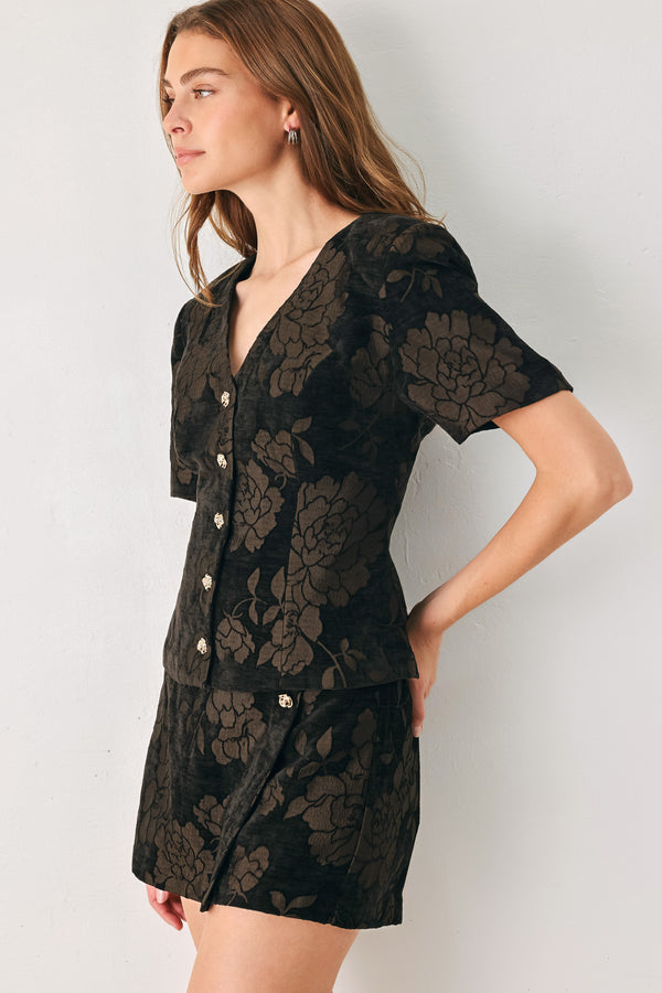 Woman wearing a short sleeve v-neck black top with brown jacquard floral pattern | FREEMARKET