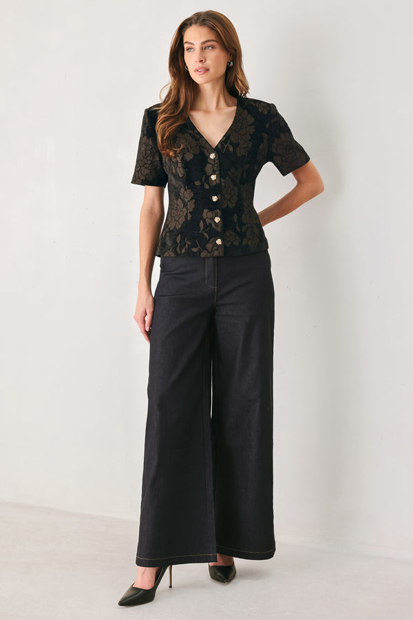 Woman wearing a short sleeve v-neck black top with brown jacquard floral pattern | FREEMARKET