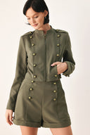 A model wearing an olive green military-style cropped jacket top with gold-tone double-breasted buttons, a front zipper, and a high mock neck | FREEMARKET
