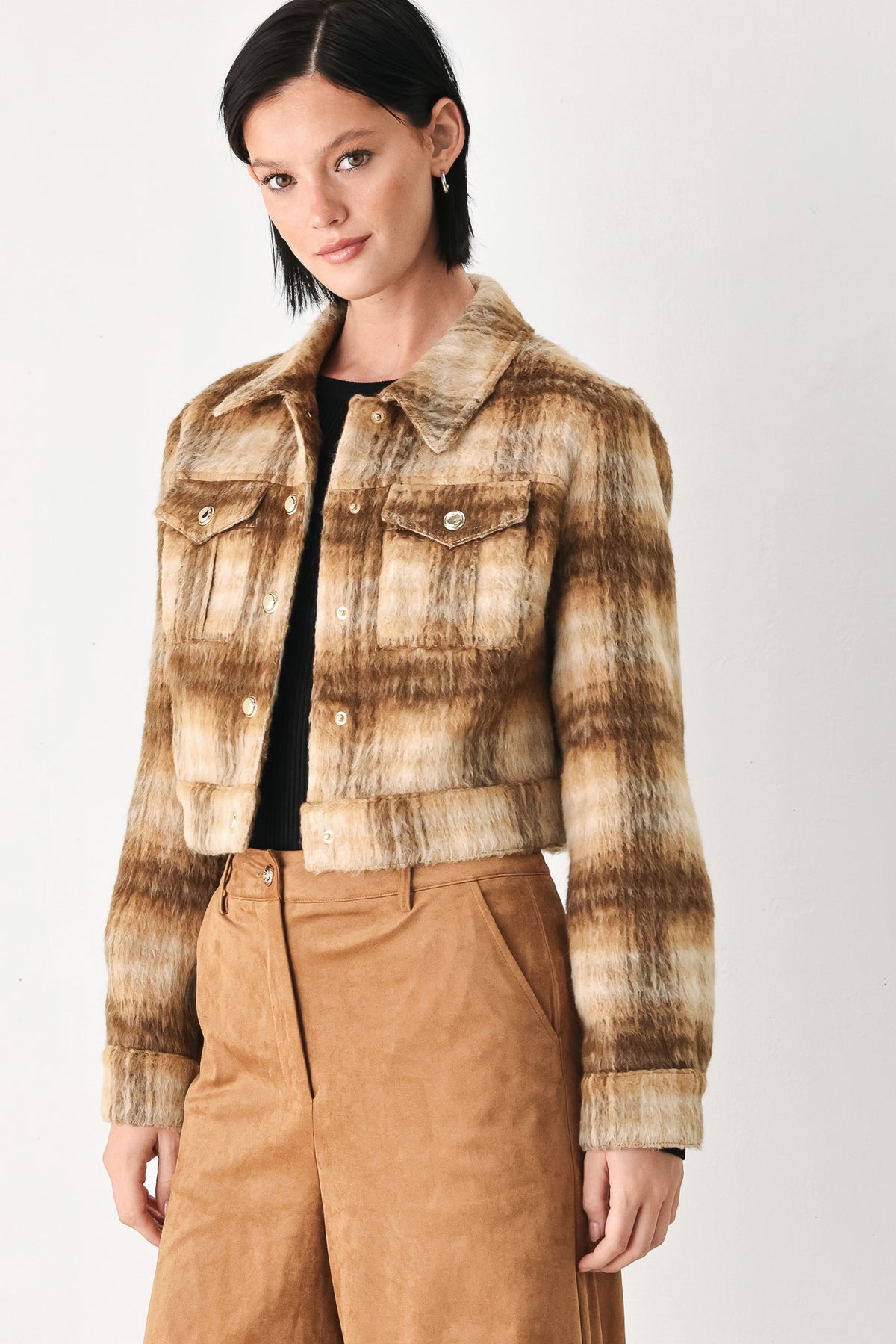 A woman models a cropped, long-sleeve plaid jacket in brown and beige tones | FREEMARKET