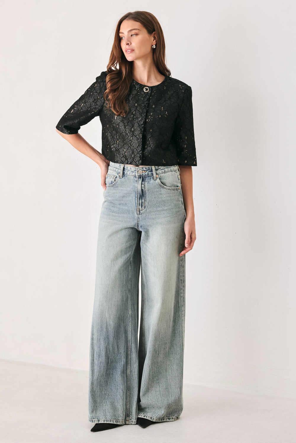 A woman wearing a black lace short-sleeve cropped top with a single button closure | FREEMARKET