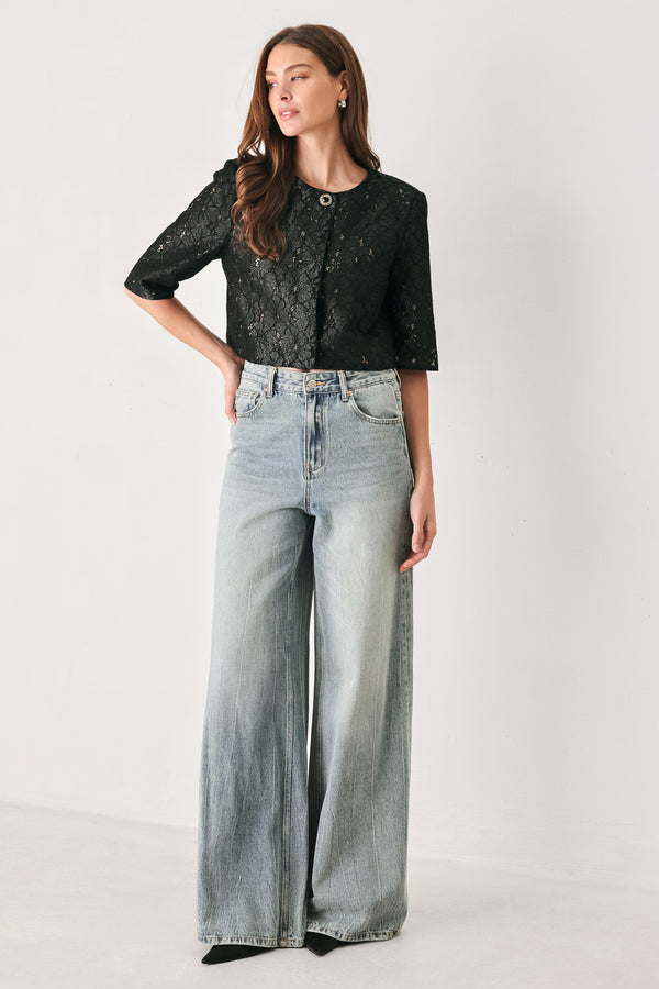 A woman wearing a black lace short-sleeve cropped top with a single button closure | FREEMARKET