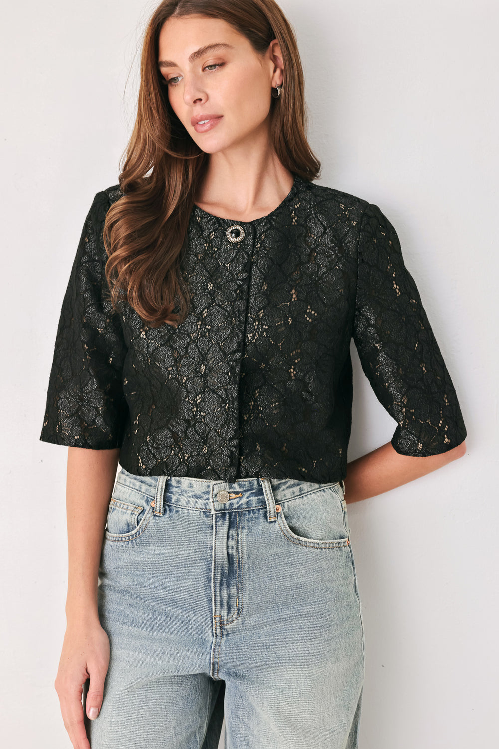 A woman wearing a black lace short-sleeve cropped top with a single button closure | FREEMARKET
