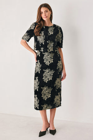 Woman wearing a black short sleeve cropped top/jacket with jacquard flowers | FREEMARKET