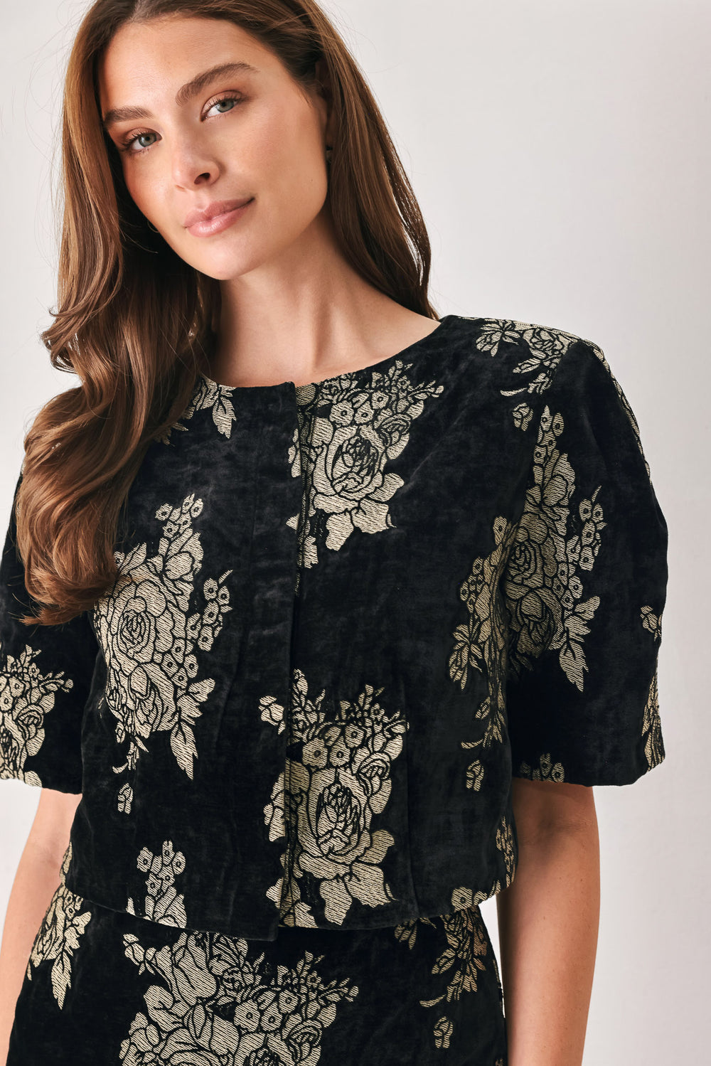Woman wearing a black short sleeve cropped top/jacket with jacquard flowers | FREEMARKET