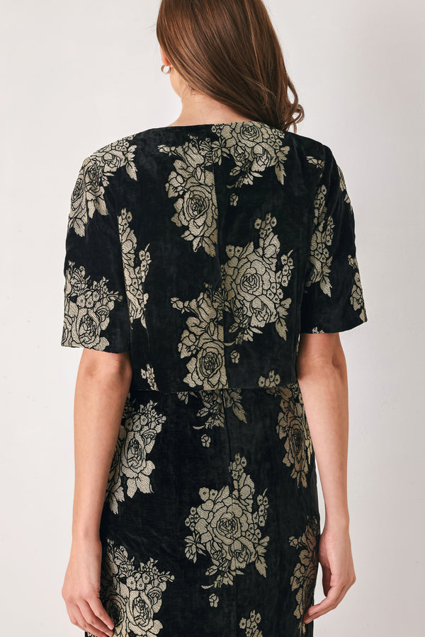Woman wearing a black short sleeve cropped top/jacket with jacquard flowers | FREEMARKET