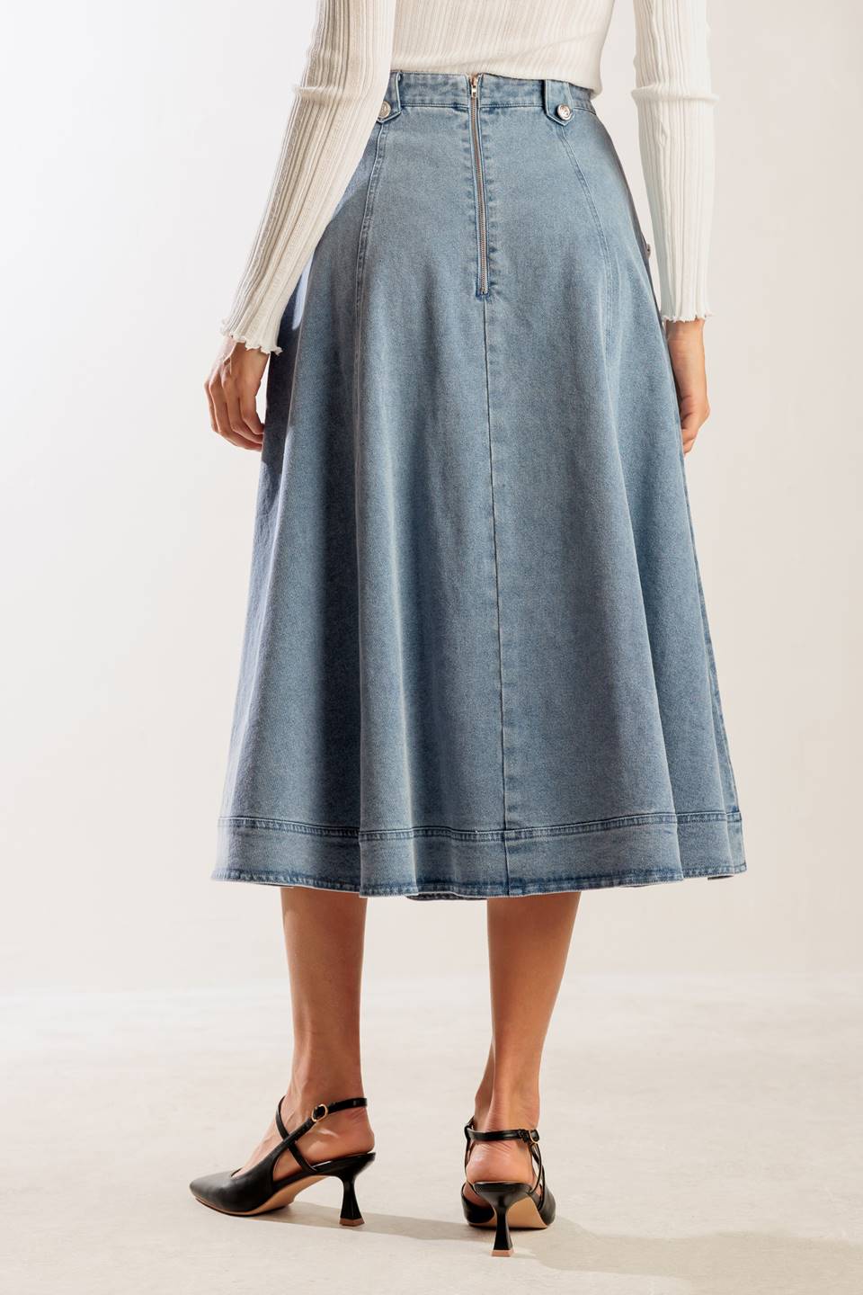 A washed denim skirt featuring button detail, A line and back zipper closure