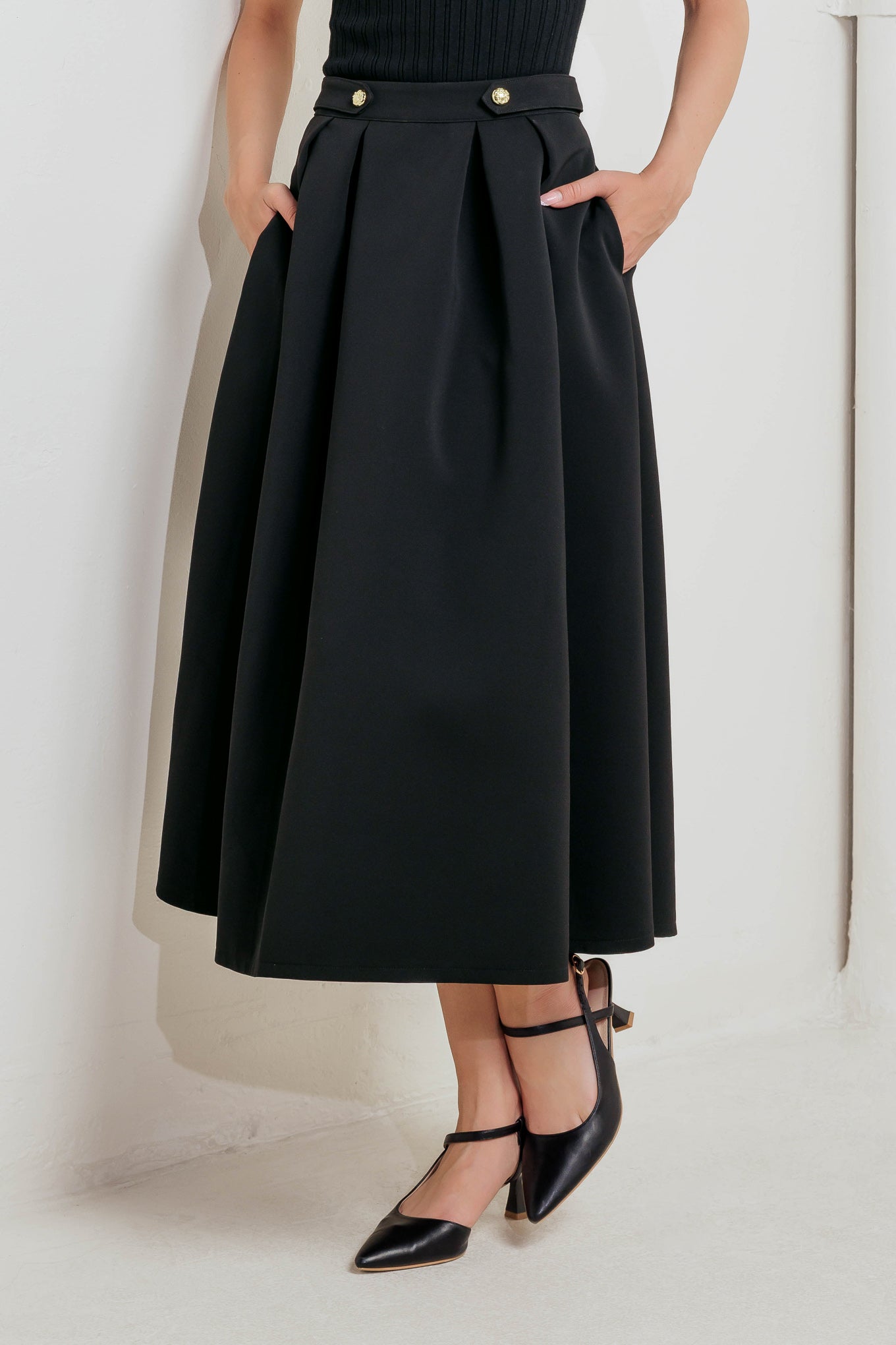 A solid woven full midi skirt featuring front button detail and back zipper closure.