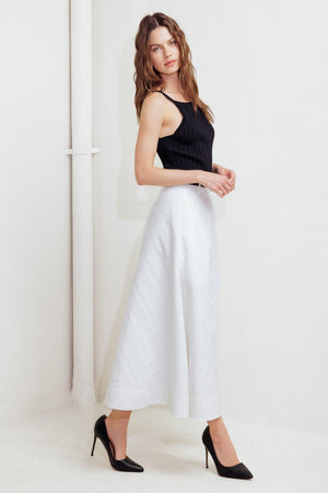 A white, textured woven midi skirt featuring a contrasting belt and back zipper closure