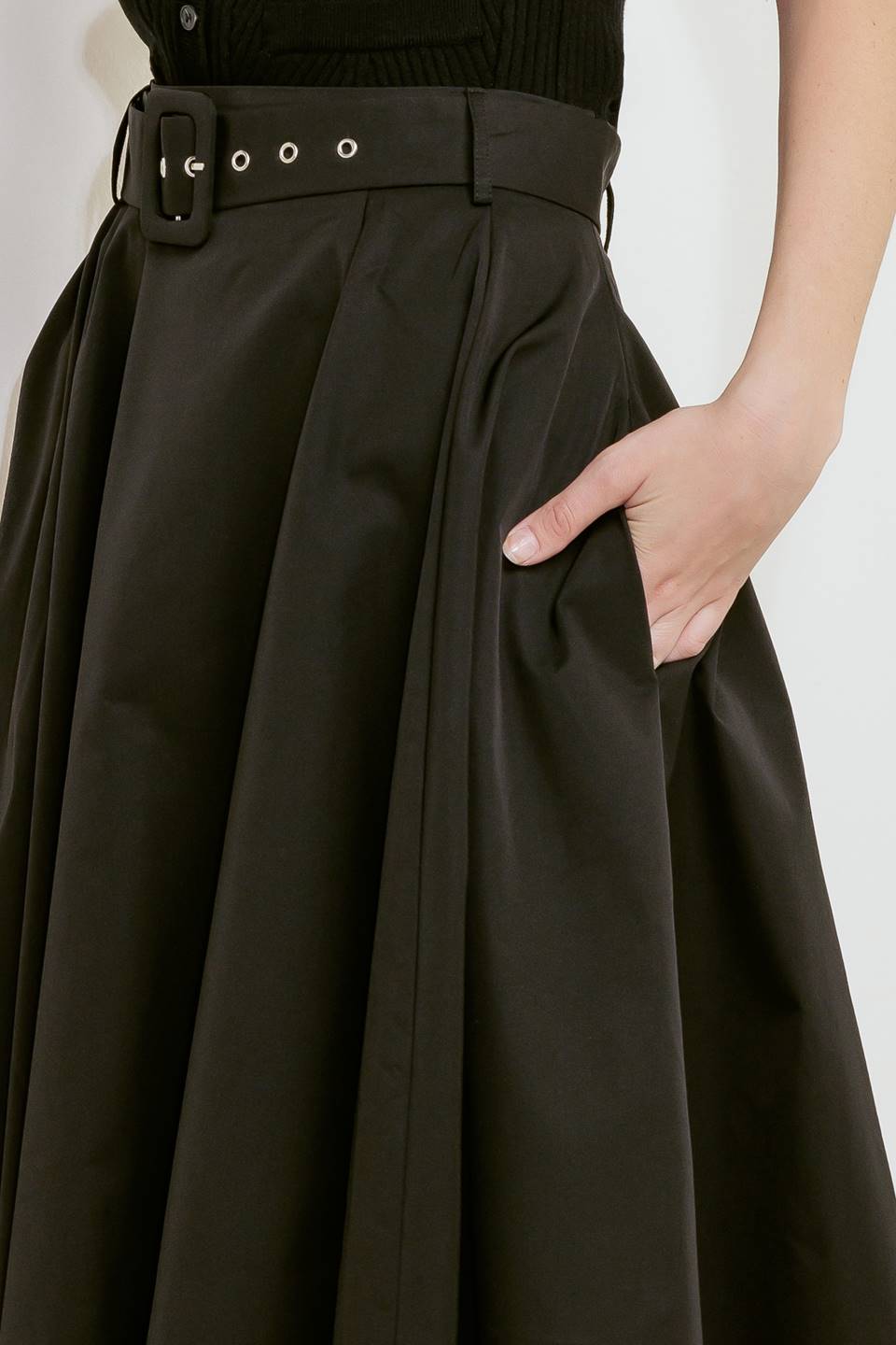 Woman wearing a black full midi skirt featuring self belt and side zipper closure | FREEMARKET
