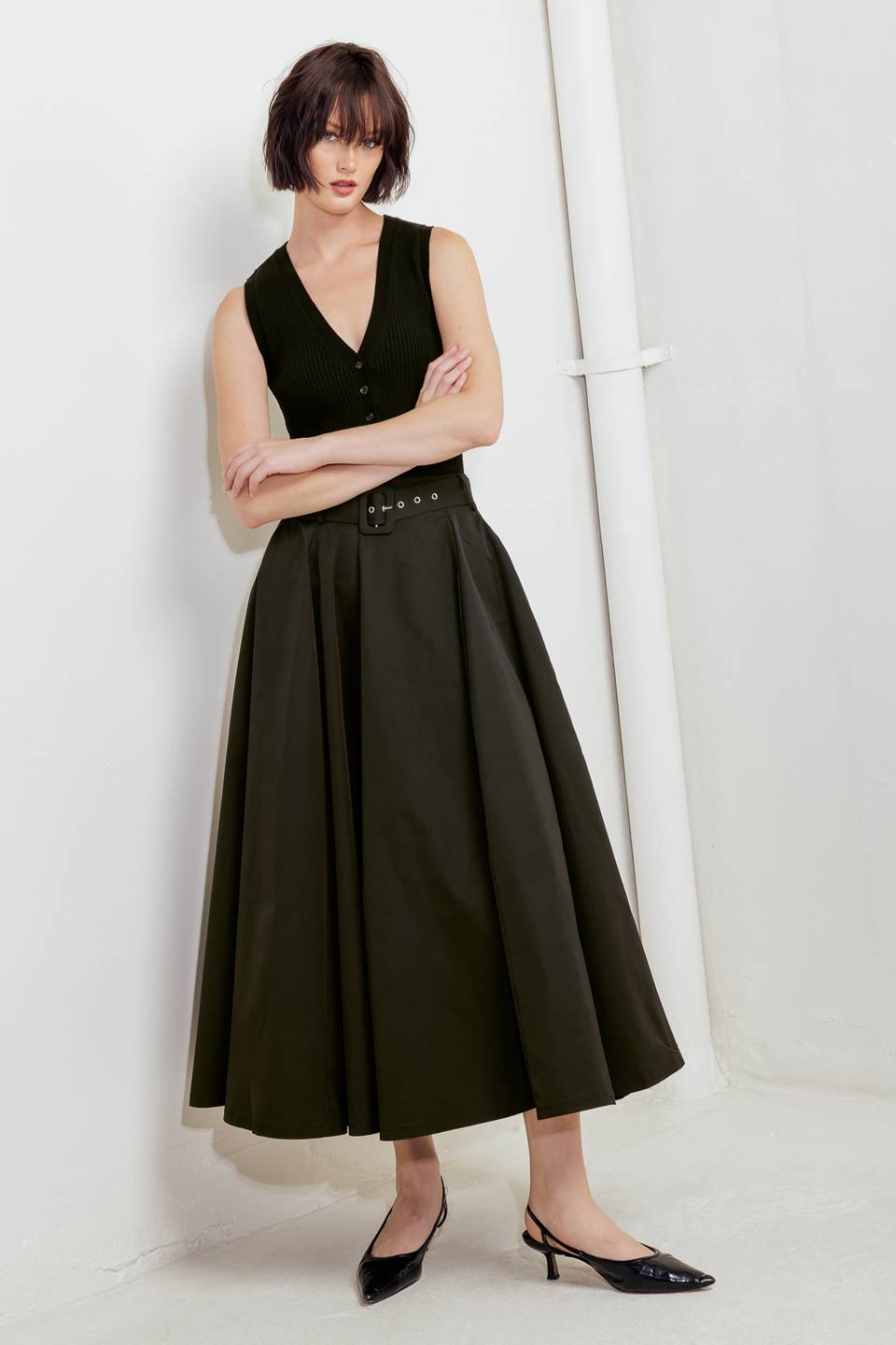 Woman wearing a black full midi skirt featuring self belt and side zipper closure | FREEMARKET
