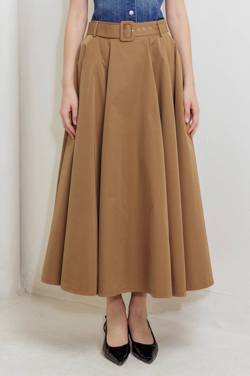 Woman wearing a camel full midi skirt featuring self belt and side zipper closure | FREEMARKET