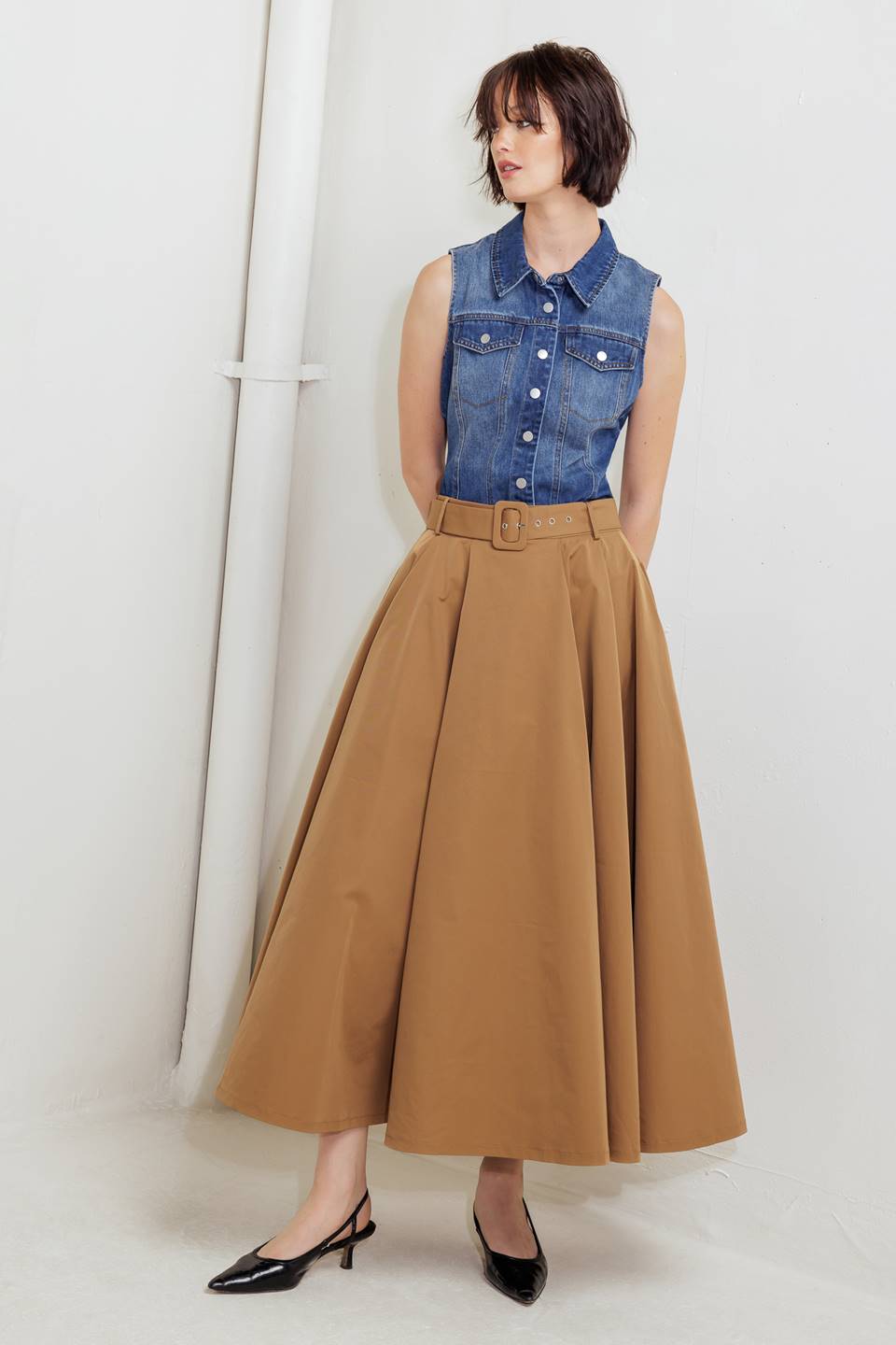 Woman wearing a camel full midi skirt featuring self belt and side zipper closure | FREEMARKET
