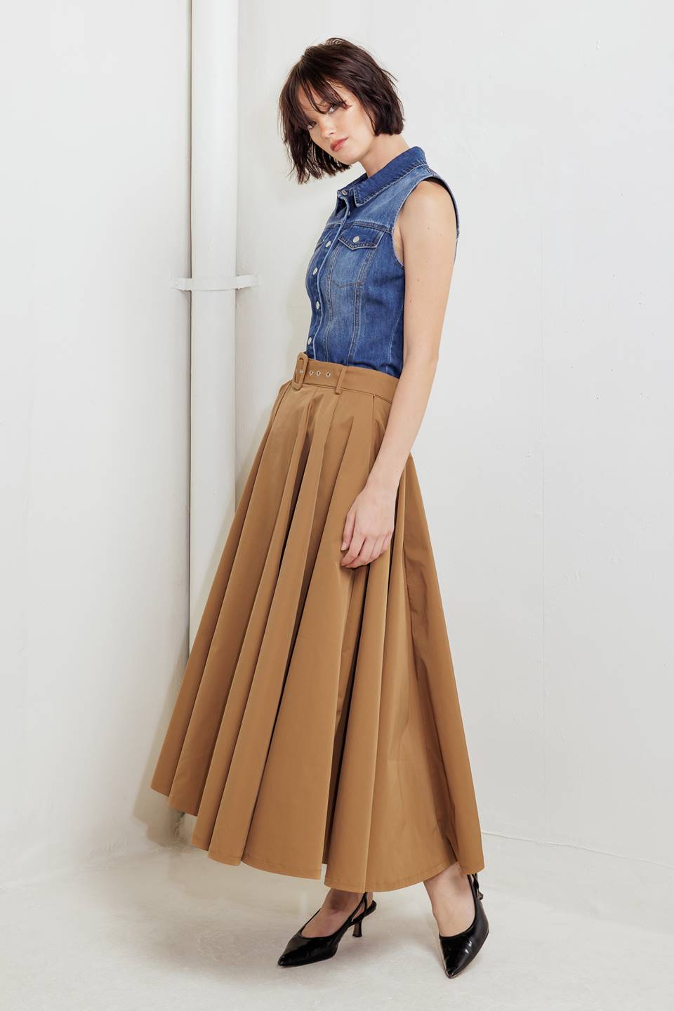 Woman wearing a camel full midi skirt featuring self belt and side zipper closure | FREEMARKET