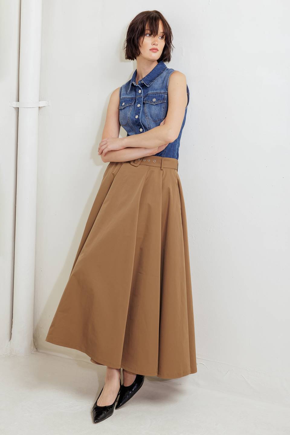 Woman wearing a camel full midi skirt featuring self belt and side zipper closure | FREEMARKET