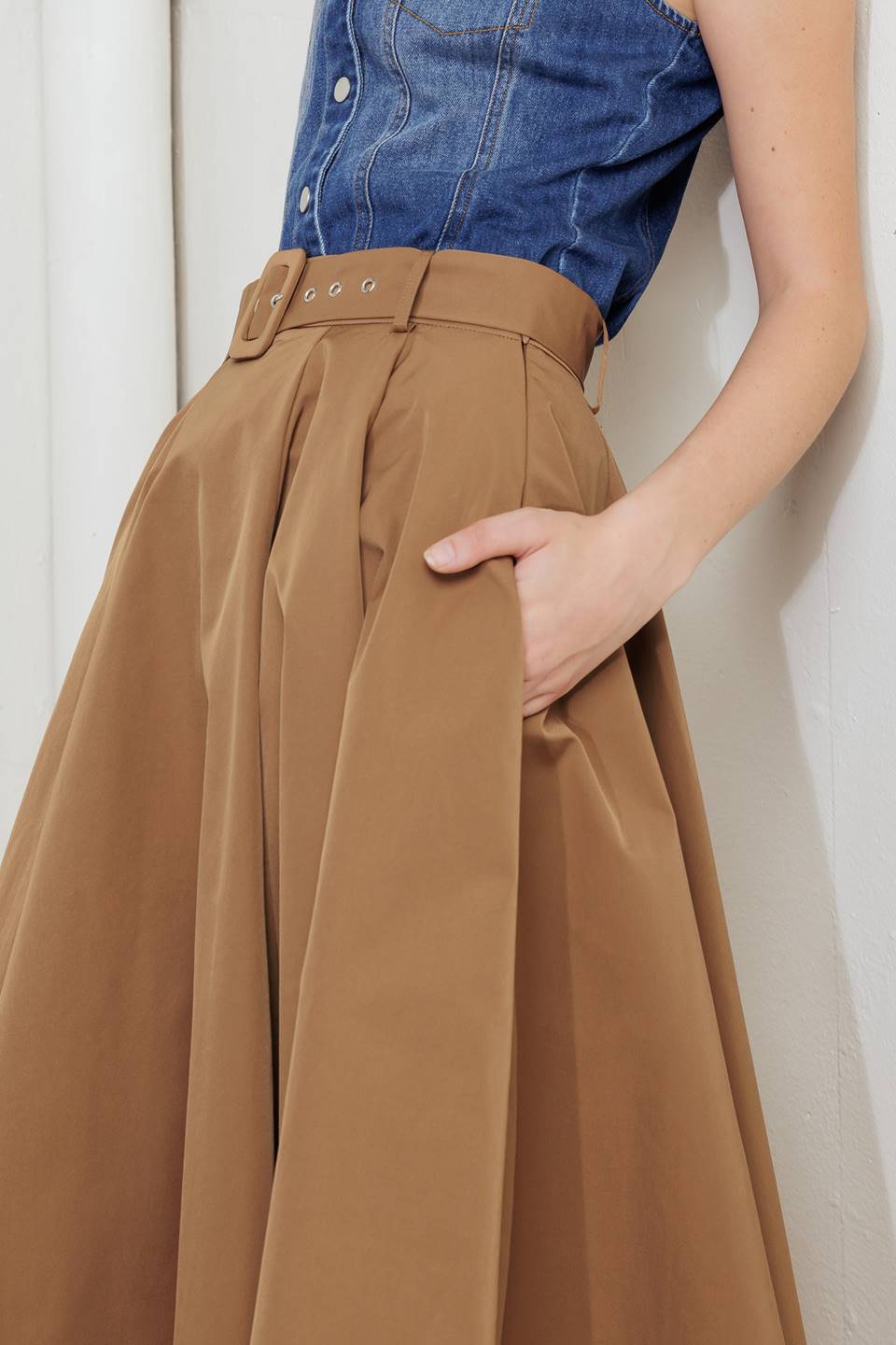 Woman wearing a camel full midi skirt featuring self belt and side zipper closure | FREEMARKET
