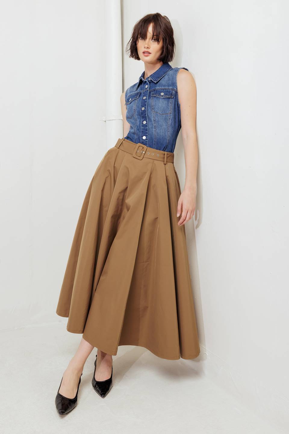 Woman wearing a camel full midi skirt featuring self belt and side zipper closure | FREEMARKET