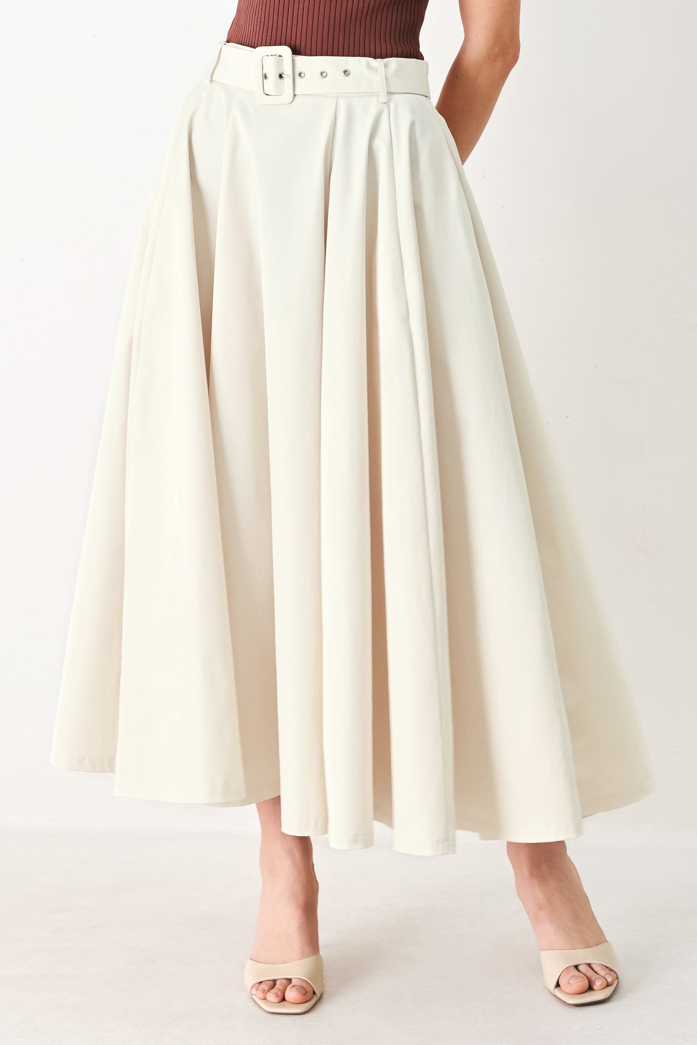 Woman wearing a white full midi skirt featuring self belt and side zipper closure | FREEMARKET
