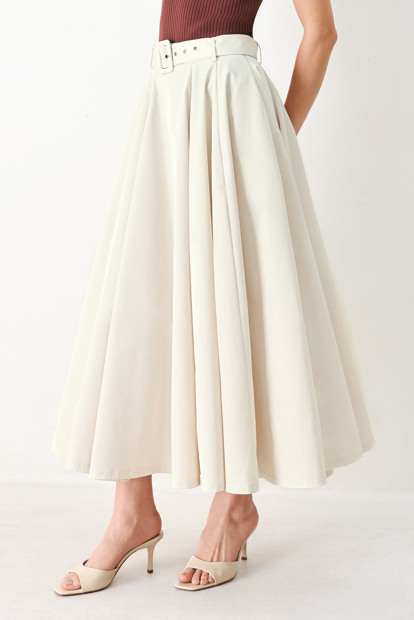 Woman wearing a white full midi skirt featuring self belt and side zipper closure | FREEMARKET