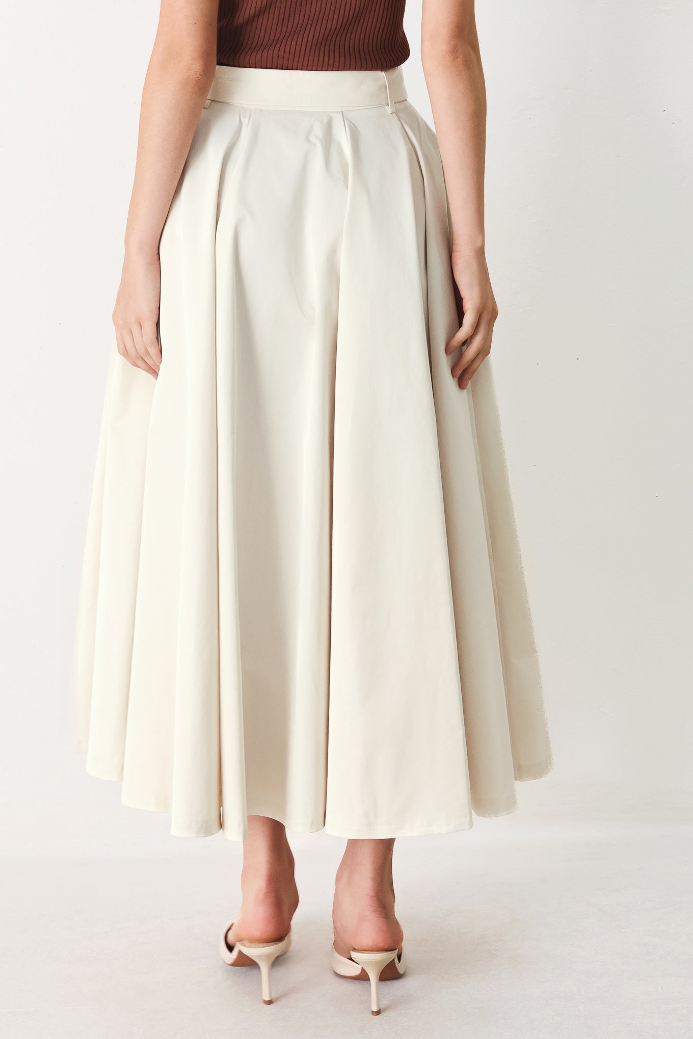 Woman wearing a white full midi skirt featuring self belt and side zipper closure | FREEMARKET